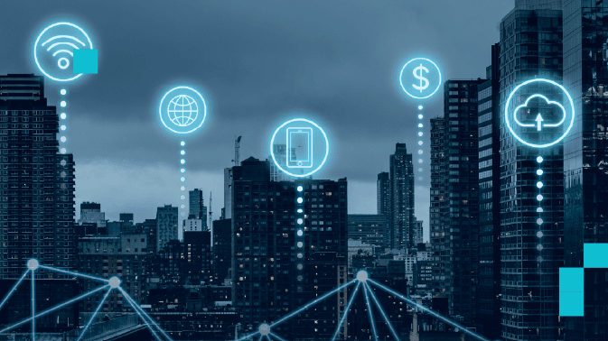 Una vista urbana nocturna con rascacielos iluminados bajo un cielo nublado. Sobre la ciudad flotan cinco iconos luminosos en azul cian conectados por líneas punteadas a una red digital que se extiende en primer plano: Wi-Fi, globo terráqueo, smartphone, símbolo de dólar y nube con flecha ascendente. La escena representa la infraestructura digital moderna —conectividad, globalización, movilidad, economía digital y computación en la nube— integrada en el tejido de las ciudades inteligentes.